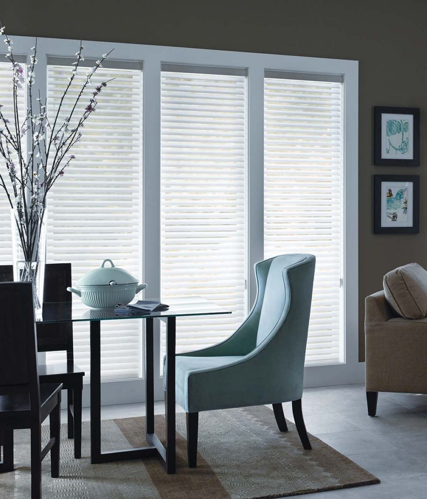 white horizontal shades on tall dining room windows with a blue chair at the head of the table