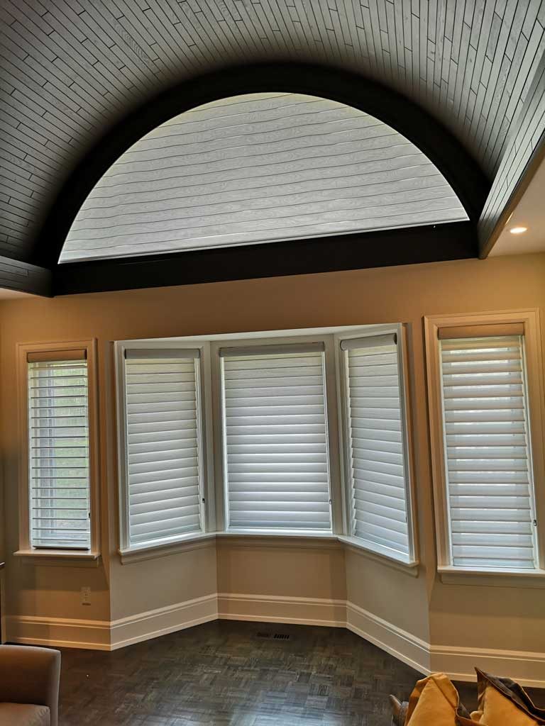 soft shades covering five rectangular windows and one large half circle window above